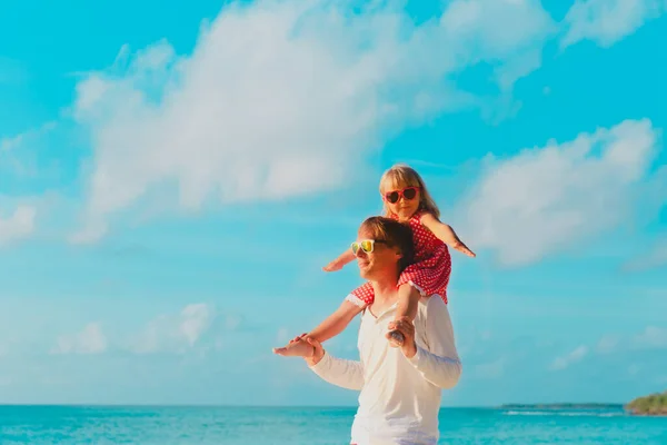 Feliz padre e hija pequeña juegan en el cielo en la playa — Foto de Stock