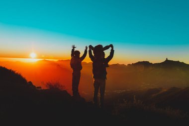 Çocuklu baba gün batımı dağlarında seyahat eder, mutlu aile doğada.