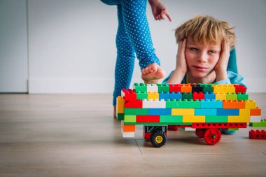 Kız kardeş onun inşaatını ve kardeşlerinin rekabetini yıkarken, üzgün çocuk stresli.