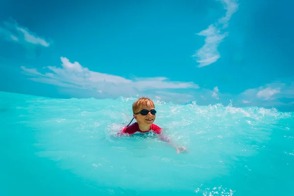 Heureux petit garçon nager et jouer avec l'eau sur la plage — Photo