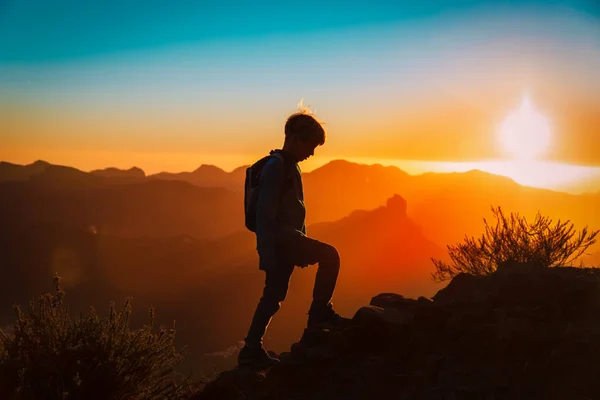 Silhouettes de jeunes garçons en randonnée dans les montagnes du coucher du soleil — Photo