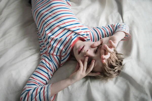Напряженный ребенок, уставший мальчик в постели, измученный ребенок дома — стоковое фото