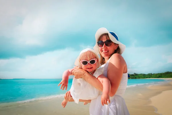 Mother holding cute little daughter on beach — Stock Photo, Image