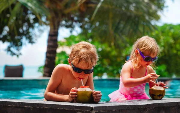 Niño y niña bebiendo cóctel de coco en el resort de playa — Foto de Stock