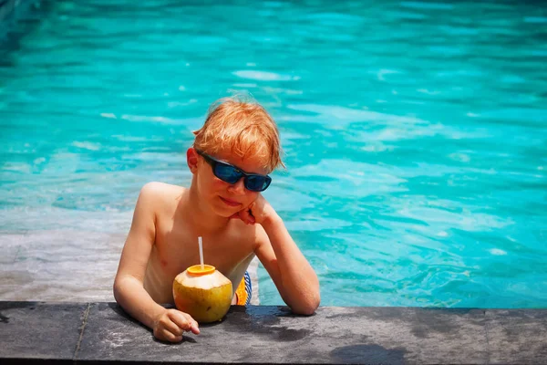 Μικρό αγόρι πίνοντας κοκτέιλ καρύδας στην παραλία θέρετρο — Φωτογραφία Αρχείου