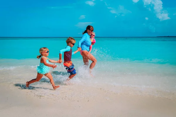 Mother with kids play with water run on beach — Stock Photo, Image