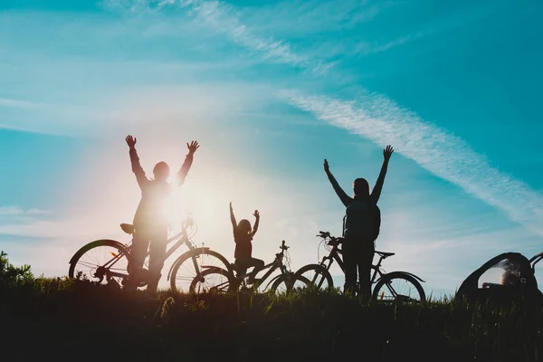 Щаслива мама, тато з дітьми, їзда на велосипеді на заході сонця, сім'я насолоджується їздовими велосипедами — стокове фото