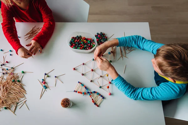 Niño y niña haciendo modelos de palos y arcilla, ingeniería y STEM — Foto de Stock