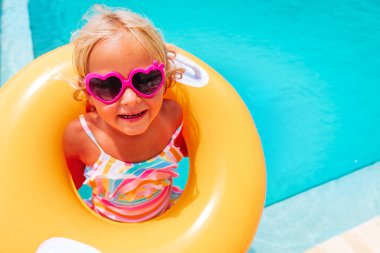 Sevimli mutlu küçük kız havuzda iyi eğlenceler.