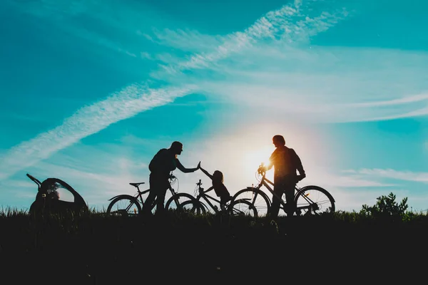 Щаслива мама, тато з дітьми катається на велосипеді на заході сонця природа — стокове фото