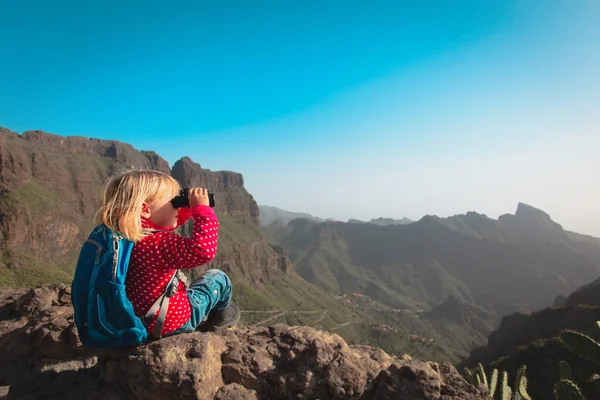 Little girl hiking in mountains looking at binoculars, famly travel — ストック写真