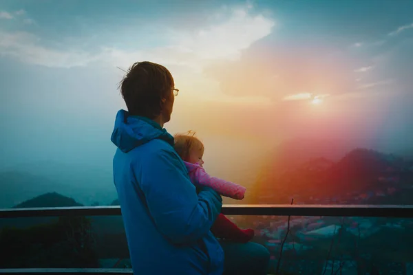 Père et bébé regardant le coucher du soleil dans les montagnes — Photo