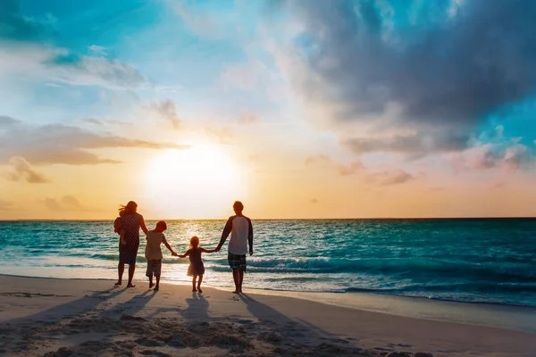 Щаслива сім'я з деревами діти ходять на пляжі заходу сонця — стокове фото