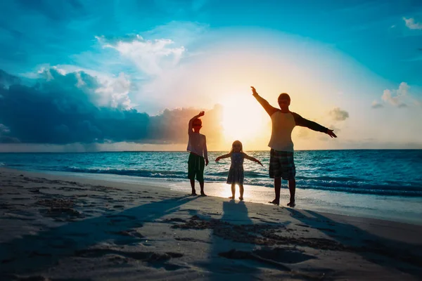 Baba ile oğlu ve kızı siluetleri oyun günbatımı Plajı'nda — Stok fotoğraf