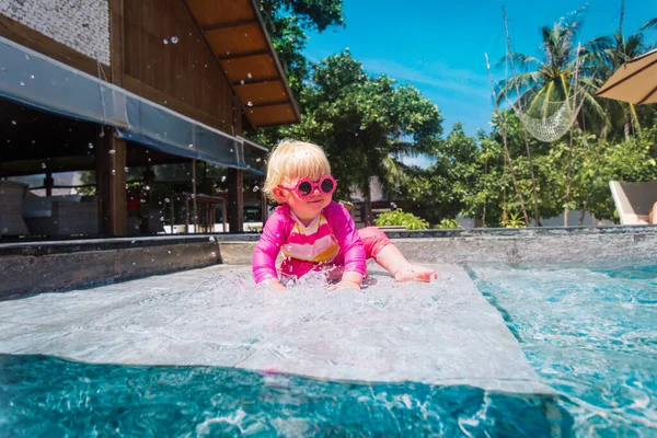 Милая маленькая девочка играет с водой в бассейне — стоковое фото