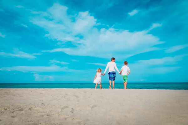 Vader met zoon en daugther wandelen op het strand — Stockfoto