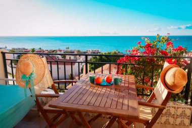 Balkon terasında deniz manzaralı iki şapka ve hafif kahvaltı.