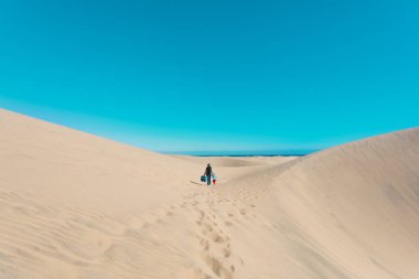 mother and little daughter walk in dunes of Maspalomas, Spain
