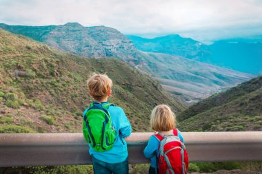 boy and girl travel in mountains, kids looking at scenic view