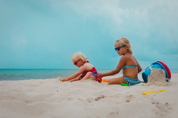 Jolies filles jouent avec le sable sur la plage d'été — Photo