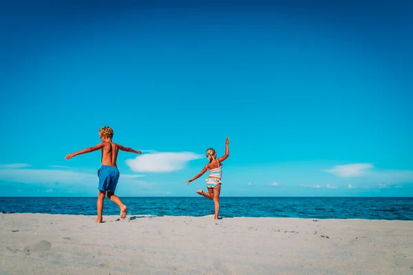 Gelukkig jongen en meisje dansen op het strand — Stockfoto