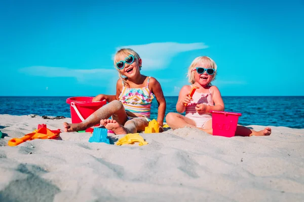 Meninas bonitos brincar com areia na praia — Fotografia de Stock