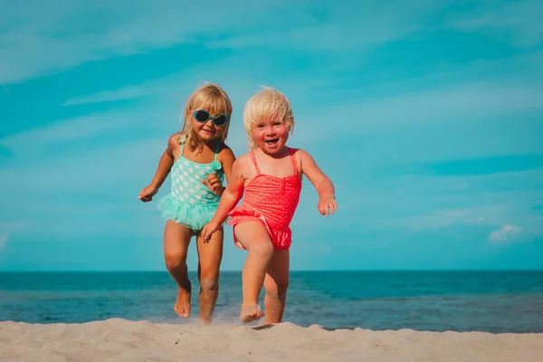 Šťastný roztomilý holčičky běžet a hrát na pláži — Stock fotografie