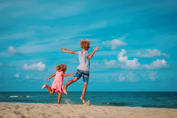 Happy boy and girl enjoy beach, kids play at sea — Stock fotografie