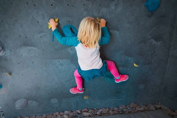 Little girl climbing on artificial boulders wall in gym — Stock Photo, Image