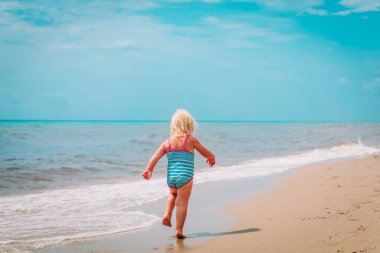 little girl going to swim at beach vacation