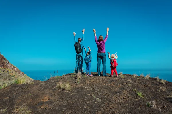 Lycklig mamma, pappa med barn reser i bergen nära havet — Stockfoto