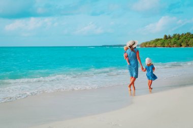 Aile sahilde tatilde. Anne ve iki çocuğu denizde.