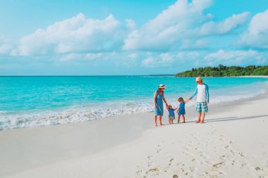 İki çocuklu mutlu aile tropik sahilde yürümek