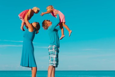 Çocuklu mutlu bir aile kumsalda oynar.