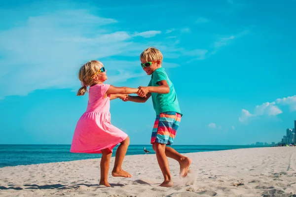 Gelukkig jongen en meisje dansen op het strand, kinderen genieten van vakantie — Stockfoto