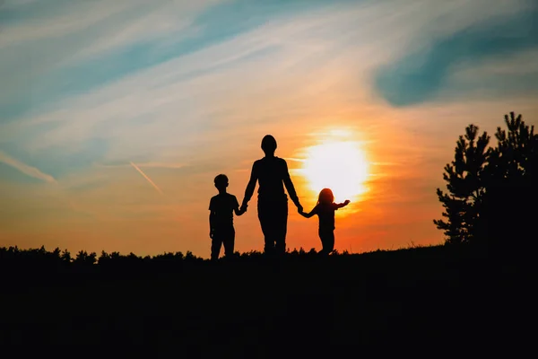 Батько з сином і дочкою ходять на заході сонця — стокове фото