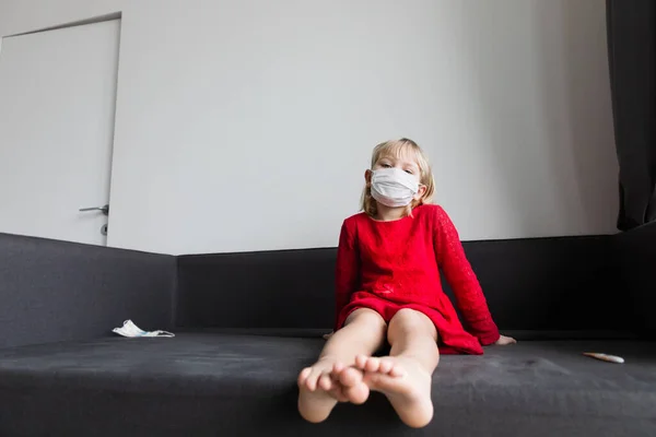 Маленька дівчинка з маскою на карантині вдома, вірусом або інфекцією — стокове фото