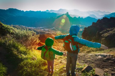 mutlu erkek ve kız gün batımında dağlarda seyahat
