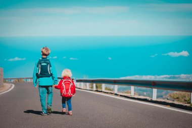 Oğlan ve kız dağlarda yolda seyahat ediyorlar.