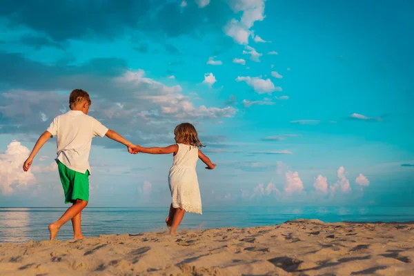 Glückliche Mädchen und Jungen spielen im Strandurlaub — Stockfoto