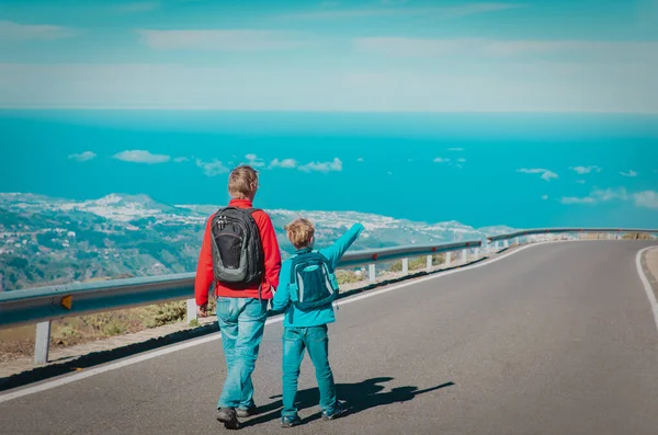 Père et fils marchant sur la route, voyage dans les montagnes — Photo