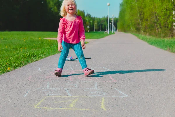 Kleines Mädchen spielt Hopscotch auf Spielplatz im Freien — Stockfoto