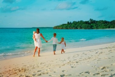 Çocuklu anne tropik plaj tatilinde yürür.