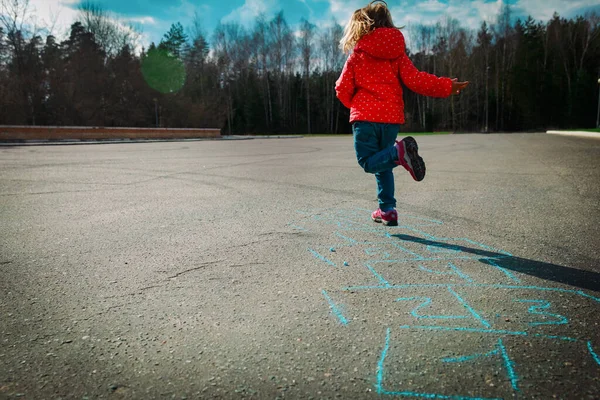 Menina jogando hopscotch ao ar livre, jogos de crianças — Fotografia de Stock