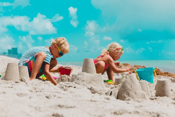 Kinderen spelen met zand op het zomerstrand — Stockfoto