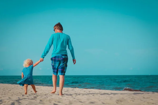Padre e hija pequeña caminan en la playa — Foto de Stock