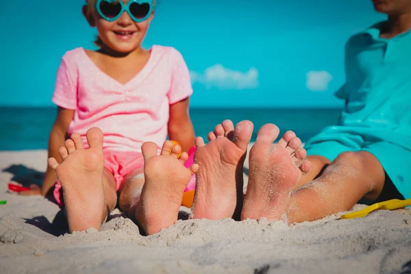 Pies de niño y niña juegan con arena en la playa —  Fotos de Stock