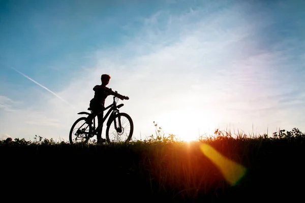 Щасливий хлопчик на велосипеді під час заходу сонця природа — стокове фото