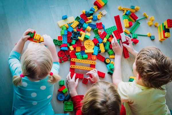 Enfants jouant avec des blocs en plastique, restant à la maison, apprenant et jouant — Photo