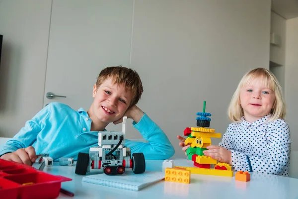 Petite fille et garçon construisant des robots à partir de blocs en plastique colorés — Photo